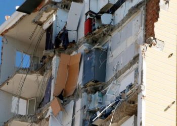 Yarısı yıkılan binanın 11'inci katında buzdolabı asılı kaldı