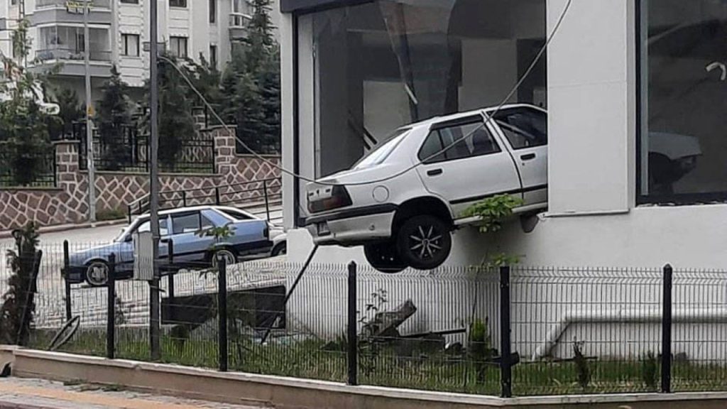 Kaldırıma çarpıp havalanan otomobil, binada asılı kaldı