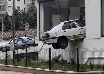 Kaldırıma çarpıp havalanan otomobil, binada asılı kaldı